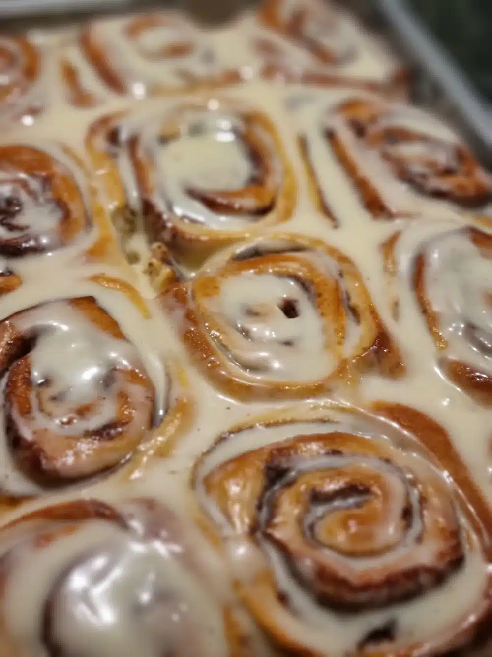 Tray of warm cinnamon rolls drizzled with creamy icing