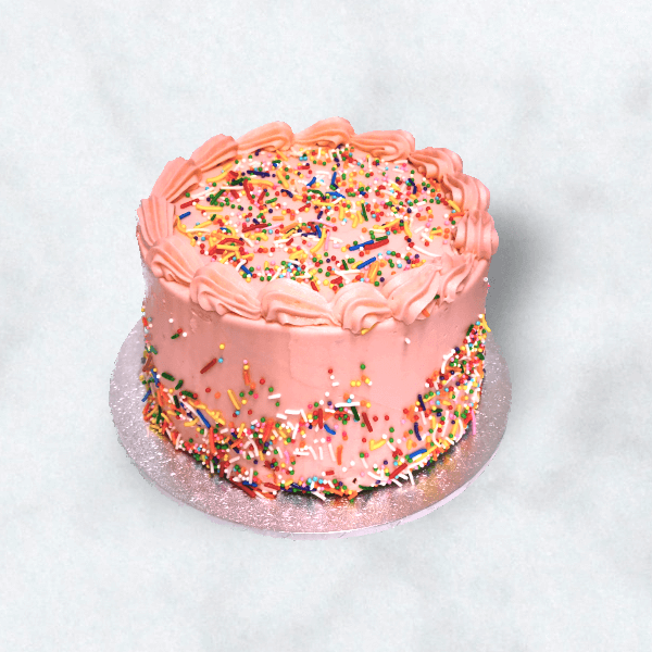 Pink buttercake with pink buttercream frosting and rainbow sprinkles.